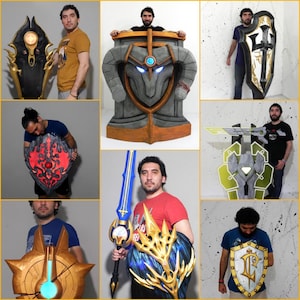 Può includere: Un collage di scudi e una spada a tema fantasy. Gli scudi variano nel design, con accenti dorati, blu e rossi. Uno scudo ha un centro luminoso. La spada è blu e oro. Gli oggetti sono esposti su uno sfondo neutro.