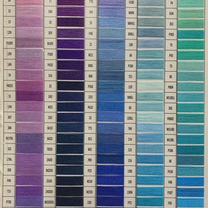 May include: Color chart featuring a wide array of thread colors, organized in columns and rows. The chart displays various shades of purple, blue, and green, with each color labeled with a unique code for easy identification. Ideal for craft projects.