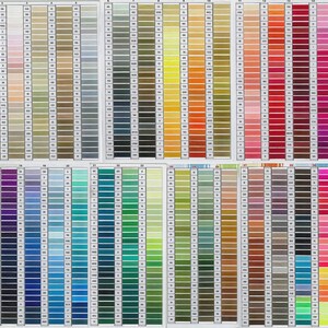 May include: A color chart displaying a wide array of thread colors, arranged in vertical columns. The colors range from light pastels to vibrant hues, including shades of beige, gray, yellow, orange, red, pink, purple, blue, green, and brown. Each color is labeled with a number.