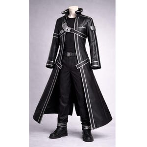 May include: Black long coat with silver trim, a high collar, and a matching belt. The outfit includes black pants and boots. The coat has a unique design with silver accents and straps.