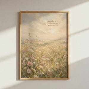 May include: A framed wall art print featuring a soft, painterly landscape of a wildflower meadow under a hazy, golden sky. The text "Consider how the wildflowers grow" and "Matthew 6:28" is printed in a delicate script in the upper right corner.