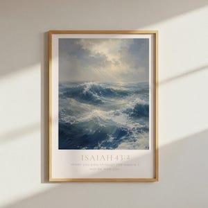 May include: A framed vertical wall art print featuring a turbulent ocean scene with deep blue waves and white foam under a cloudy sky with light rays. The text Isaiah 43:2 and the phrase When you pass through the waters, I will be with you appear below.