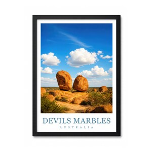 May include: A framed wall art print featuring a landscape of large, rounded orange boulders at Devils Marbles in Australia under a bright blue sky with white clouds. The text "DEVILS MARBLES" and "AUSTRALIA" is printed in blue at the bottom.