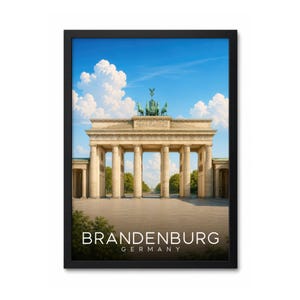 Może przedstawiać: Oprawiony wydruk ścienny przedstawiający Bramę Brandenburską w Berlinie w Niemczech pod jasnoniebieskim niebem z białymi chmurami. Napis BRANDENBURG GERMANY jest wydrukowany białymi wielkimi literami w dolnej części obrazu w czarnej ramie.