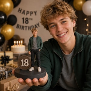 May include: A custom 3D figurine of a young person with curly blonde hair, wearing a dark green zip-up jacket, gray t-shirt, black trousers, and white sneakers. The figurine stands on a circular base next to a round plaque featuring the number 18.