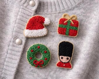 Conjunto de cuatro broches cuadrados con motivos florales, elaborados con la técnica de punzonado.