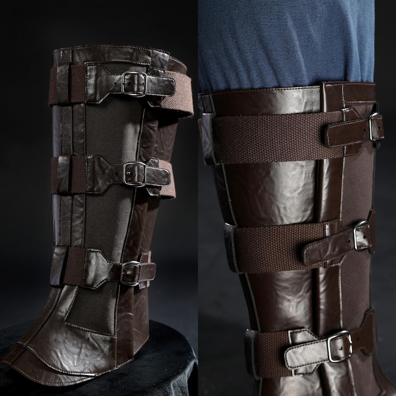May include: Brown leather knee-high boots with multiple straps and silver buckles. The boots have a textured appearance and are designed with a series of horizontal straps secured by buckles. The boots are likely part of a costume or cosplay.