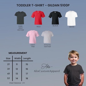 May include: A Gildan 5100P toddler t-shirt color chart featuring dark gray heather, red, black, white, light pink, and athletic heather options. Includes a measurement table for sizes 2T through 5T with width and length in inches, plus a child wearing a black t-shirt.