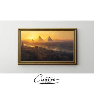 May include: A framed landscape painting depicting the pyramids of Giza at sunset. The artwork features a warm color palette of gold, orange, and brown, with a detailed cityscape in the foreground. The frame is gold and ornate, with the text "Creative Fine Gallery" at the bottom.