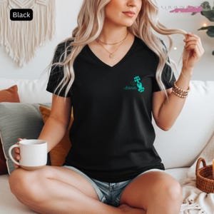 May include: Black V-neck t-shirt with a teal graphic of a race car and the name "Antonelli". The shirt is made of a soft material.