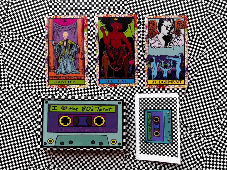 May include: Three tarot cards titled Justice, The Devil, and Judgement displayed above a rectangular box and a small card featuring a purple and teal cassette tape graphic with the text I heart the 80's Tarot by Christy Plummer Reynosa.