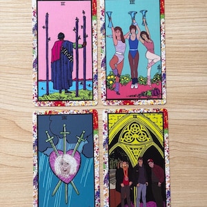 May include: Four tarot cards featuring colourful illustrations. Top left: a figure in a blue robe with three wooden staves. Top right: three people in athletic wear holding blue cups. Bottom left: a heart pierced by three swords. Bottom right: three people standing under a yellow archway.