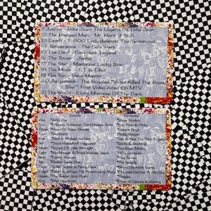 May include: Two rectangular cards with a black and white checkerboard pattern border. The cards feature lists of 1980s pop culture references paired with tarot card names, including Justice, The Hanged Man, Death, Swords, and Pentacles.