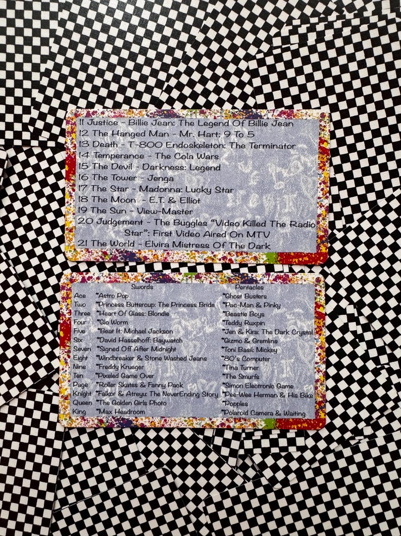 May include: Two rectangular cards with a black and white checkerboard pattern border. The cards feature lists of 1980s pop culture references paired with tarot card names, including Justice, The Hanged Man, Death, Swords, and Pentacles.