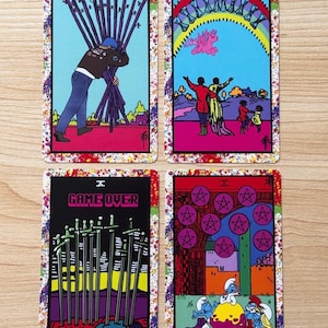 May include: Four rectangular tarot cards with colourful borders. Top left: a figure carrying ten wands. Top right: figures under a rainbow with winged creatures. Bottom left: ten swords with the text GAME OVER. Bottom right: blue creatures near coins.