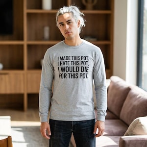 Könnte beinhalten: Hellgraues Langarmshirt mit dem schwarzen Text: "I MADE THIS POT. I HATE THIS POT. I WOULD DIE FOR THIS POT." Das Shirt besteht aus einem weichen Material und eignet sich für Freizeitkleidung.