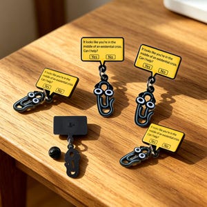 May include: Several black paperclip charms with googly eyes and yellow speech bubble pendants. The pendants display the text, "It looks like you're in the middle of an existential crisis. Can I help?" with "Yes" and "No" options.