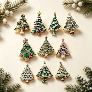 May include: A collection of ten Christmas tree brooches in various designs, featuring green, gold, and silver metal finishes with accents of red, white, and multicoloured rhinestones, pearls, and enamel detailing in a triangular tree shape.