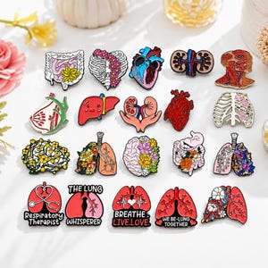 Puede incluir: Una colección de veinte pines de esmalte con diseños anatómicos que incluyen corazones, pulmones, cerebros y órganos digestivos, muchos decorados con motivos florales. Varios pines incluyen texto como Respiratory Therapist, The Lung Whisperer, BREATHE.LIVE.LOVE, WE BE-LUNG TOGETHER y Just go breathe.