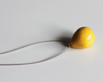 Mustard yellow handmade porcelain tear drop necklace on gray silk cord