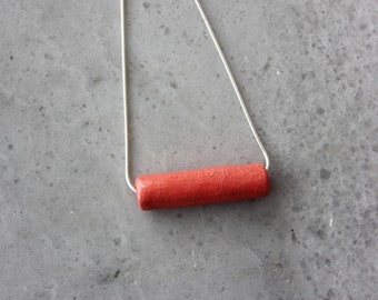 Handmade porcelain tube necklace on a silver chain, coral red ceramic pendant