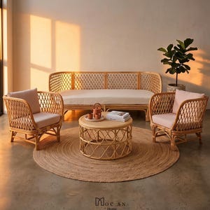 Könnte beinhalten: Ein Wohnzimmerset mit einem geflochtenen Rattan-Sofa, zwei Sesseln und einem runden Couchtisch. Die Stühle und das Sofa haben hellrosa Kissen. Ein runder Jute-Teppich und eine Topfpflanze vervollständigen die Szene.