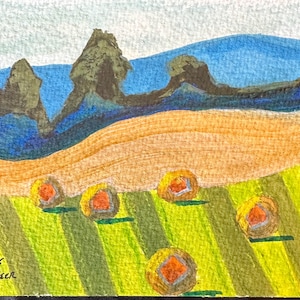 May include: Watercolor painting of a rural landscape with a field of hay bales. The artwork features a green and yellow field, a tan hillside, and a blue sky with dark green mountain shapes. Signed "Mark Green".