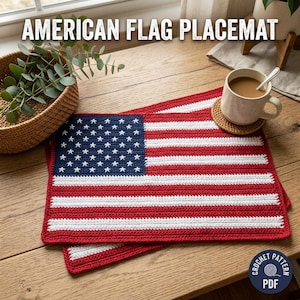 May include: A rectangular crochet placemat featuring the American flag design with a blue canton containing white stars and alternating horizontal red and white stripes. The text AMERICAN FLAG PLACEMAT is visible at the top, and a PDF icon is at the bottom.