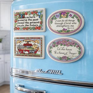 May include: Four decorative plaques attached to a light blue refrigerator. Two are rectangular with illustrations of apples and Noah's Ark, and two are oval with floral borders and religious text including 'Teachers preserve the past' and 'Let this house be a house of Prayer'.