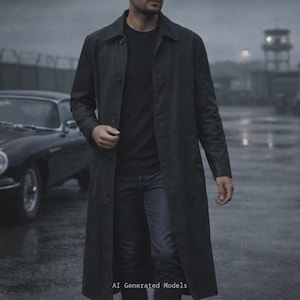 May include: A long, dark charcoal grey trench coat worn over a black t-shirt and dark denim jeans. The coat features a classic collar, a button-front closure, and long sleeves. The text AI Generated Models is visible at the bottom of the image.