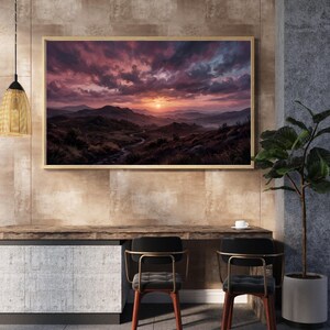 Könnte beinhalten: Gerahmtes Landschaftsgemälde mit Sonnenuntergang über Hügeln und einem Fluss. Der Himmel ist mit lila, rosa und orangefarbenen Wolken gefüllt. Das Kunstwerk wird über einem Holztisch mit zwei Stühlen ausgestellt. Das Gemälde ist ca. 120 cm breit.
