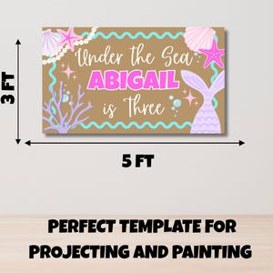 May include: A rectangular banner measuring 3 feet by 5 feet with a tan background. It features the text "Under the Sea ABIGAIL is Three" in white and pink. The design includes illustrations of pink starfish, seashells, a mermaid tail, and coral.