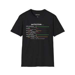Puede incluir: Camiseta negra con el texto "INITIALIZING..." y un gráfico de barra de progreso. El gráfico muestra porcentajes para "Coffee Dependency", "Patience", "Will to Debug", "Desire to Help Users", "Blame Deflection" y "Caffeine Tolerance".