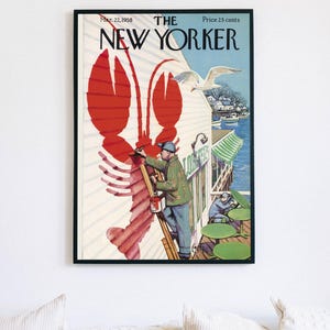 May include: Framed print of a vintage New Yorker magazine cover from March 22, 1958. The cover art shows a large red lobster painted on a building, with a man on a ladder painting it. A seagull flies nearby.