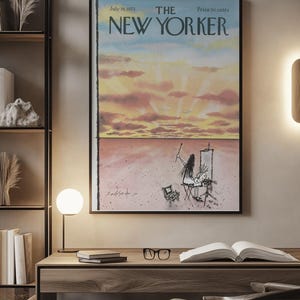 May include: A framed magazine cover print titled The New Yorker, dated July 16, 1973, featuring a watercolor illustration of a person painting a sunset landscape with pink clouds and a vast horizon, displayed in a black frame on a wall.