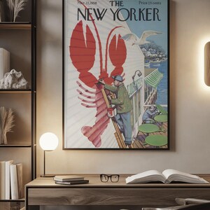 May include: A framed vintage New Yorker magazine cover with a red lobster illustration. The cover art shows a man painting a lobster, a seagull, and the text "The New Yorker" and "Mar. 22, 1958".