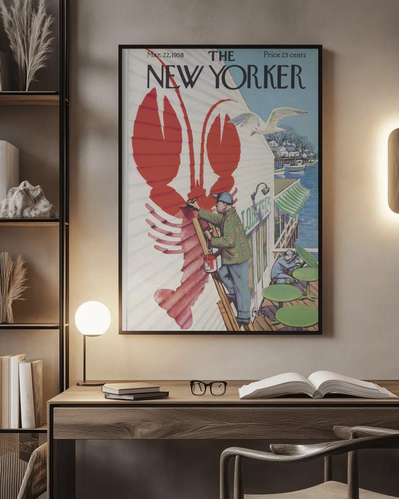 May include: A framed vintage New Yorker magazine cover with a red lobster illustration. The cover art shows a man painting a lobster, a seagull, and the text "The New Yorker" and "Mar. 22, 1958".