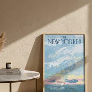 May include: A framed vintage New Yorker magazine cover from June 14, 1969, featuring a sailboat on the ocean under a colorful sky. The cover art is in shades of blue, pink, and yellow, with the magazine title at the top.