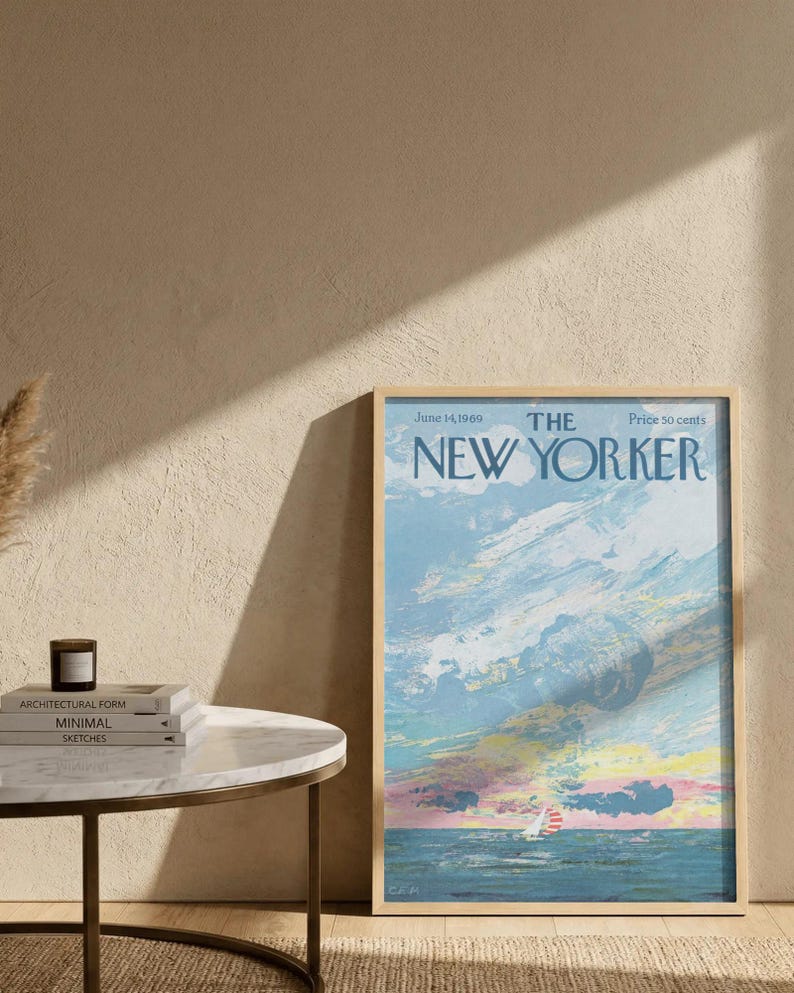May include: A framed vintage New Yorker magazine cover from June 14, 1969, featuring a sailboat on the ocean under a colorful sky. The cover art is in shades of blue, pink, and yellow, with the magazine title at the top.