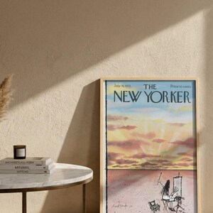 May include: A framed magazine cover of The New Yorker dated July 16, 1973, featuring a watercolor illustration of a sunset sky above a desert landscape with a figure painting at an easel. The text reads The New Yorker, July 16, 1973, Price 50 cents.