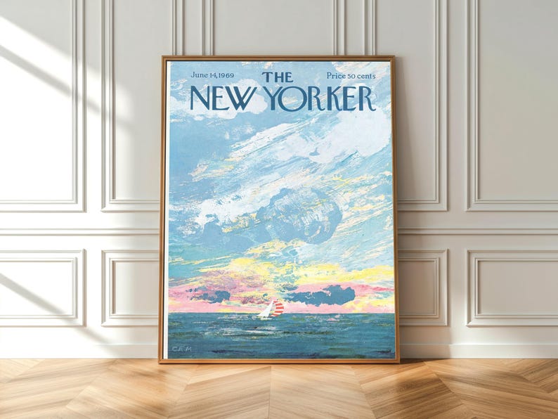 May include: A framed print of a vintage New Yorker magazine cover. The artwork depicts a sailboat on the ocean under a cloudy sky with pastel colors. The text reads "The New Yorker" and the date "June 14, 1969."