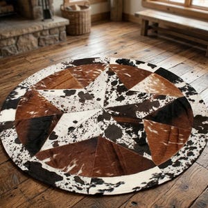 Puede incluir: Una alfombra circular construida con paneles de piel de vaca en tonos marrón, negro y blanco. Las piezas están dispuestas para formar un gran patrón de estrella central, con un borde de segmentos de piel moteada rodeando el diseño.