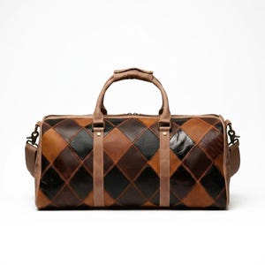 May include: A duffel bag featuring a diamond-patterned patchwork design in shades of black, dark brown, and tan leather. The bag includes two top handles, a detachable shoulder strap with metal hardware, and a zippered main compartment closure.