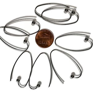 May include: Six silver hoop earrings with a small ball at the end of each hoop. The earrings are arranged in a starburst pattern.