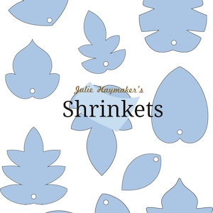 May include: A set of ten blue leaf-shaped shrink plastic templates for crafting. The templates are designed for use with shrink plastic, a type of plastic that shrinks when heated. The templates feature a variety of leaf shapes, including simple leaves, compound leaves, and palm leaves. The templates are labeled "Julie Haymaker's Shrinkets".