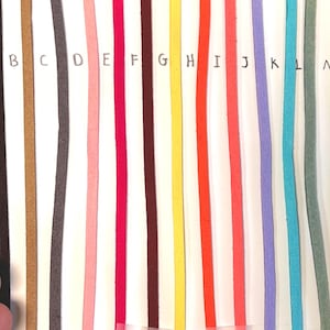 May include: A selection of 14 different coloured cords, labelled A through N. The cords are all the same width and are arranged in a row.