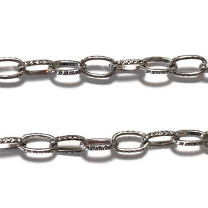 K&ouml;nnte beinhalten: Eine silberne Kette mit ovalen Gliedern. Die Glieder haben eine strukturierte Oberfl&auml;che.