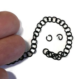 20 small black  stainless steel jump rings on a strand