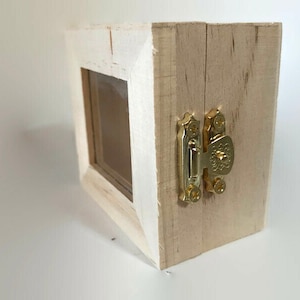May include: A small wooden box with a clear glass window and a gold latch. The box is painted white and has a distressed finish.