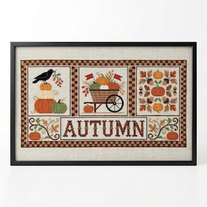 Puede incluir: Obra de arte en punto de cruz enmarcada con temas otoñales. El diseño incluye calabazas, un cuervo, una carretilla y la palabra "AUTUMN". La paleta de colores consiste en naranja, verde, marrón y beige.